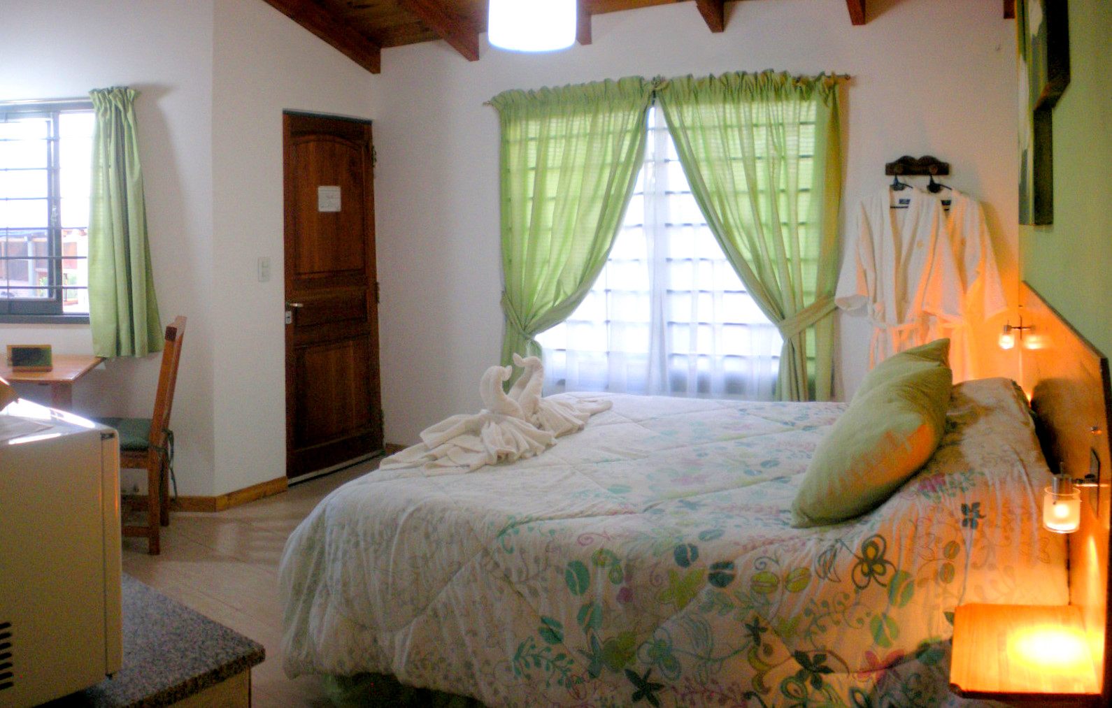 Interior cálido de una cabaña del complejo, con cama matrimonial preparada para los huéspedes